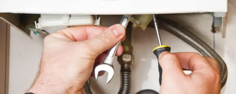 Boiler repair technician tightening pipe fittings and connections in El Paso, TX