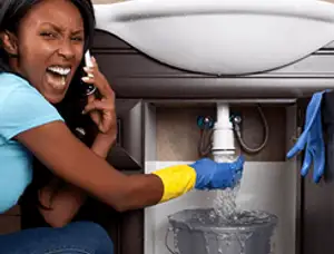 Emergency plumbing repair for a leaking sink drain under a bathroom vanity in El Paso, TX