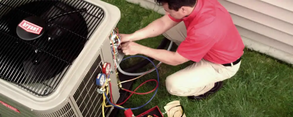 HVAC technician servicing an outdoor air conditioner unit in El Paso, TX