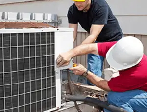 HVAC technicians repairing an outdoor AC unit on a rooftop in El Paso, TX