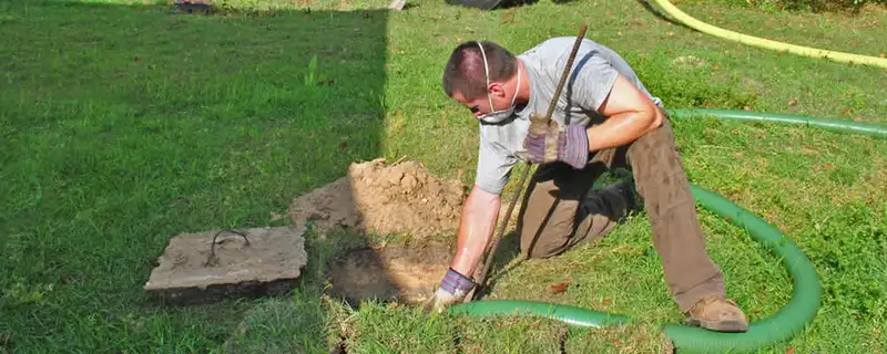 Septic pumping technician servicing a residential septic tank in El Paso, TX