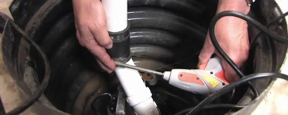 Sump pump installation technician connecting PVC discharge piping in El Paso, TX